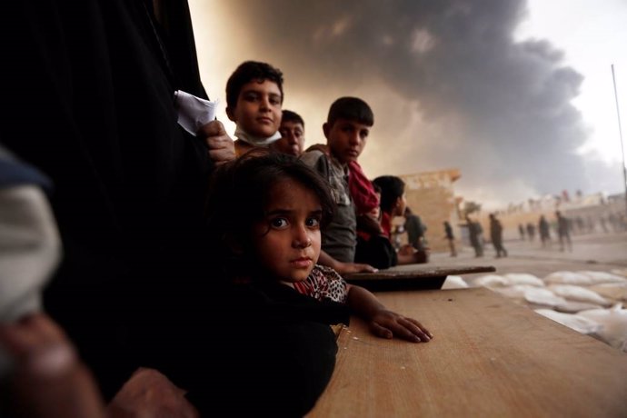 Niños esperando para recibir comida a las afueras de Mosul 