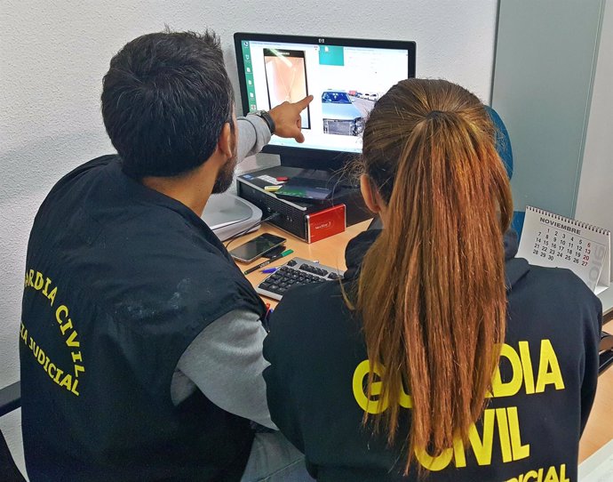 Dos guardias civiles frente a la pantalla de un ordenador