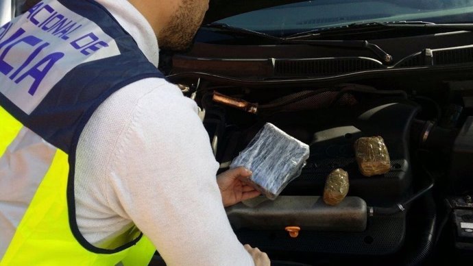 Un agente inspecciona la droga localizada en un coche