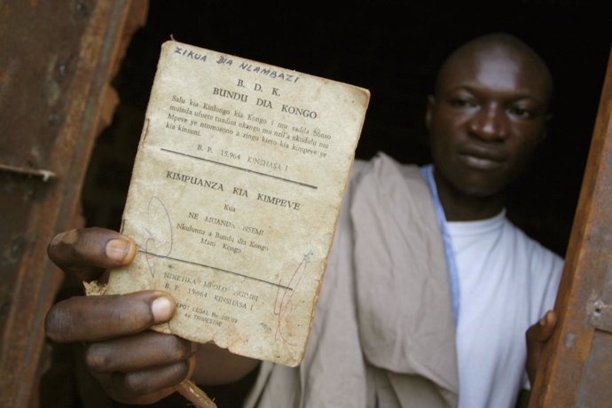 Un hombre muestra un manifiesto de la secta Bundu dia Kongo
