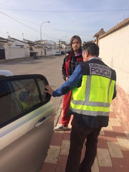 El joven junto a un agente en el momento de la detención