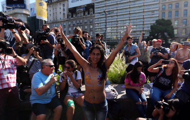 A woman poses topless during a protest in response to a recent incident on an Ar