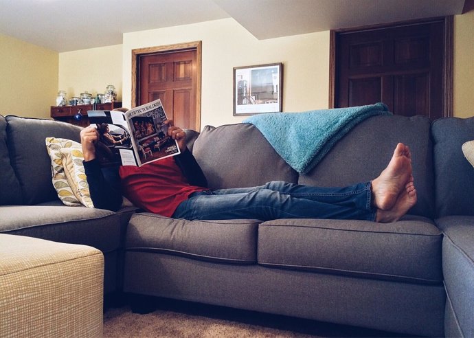 Hombre tumbado en el sofá, sedentarismo, descanso, relax