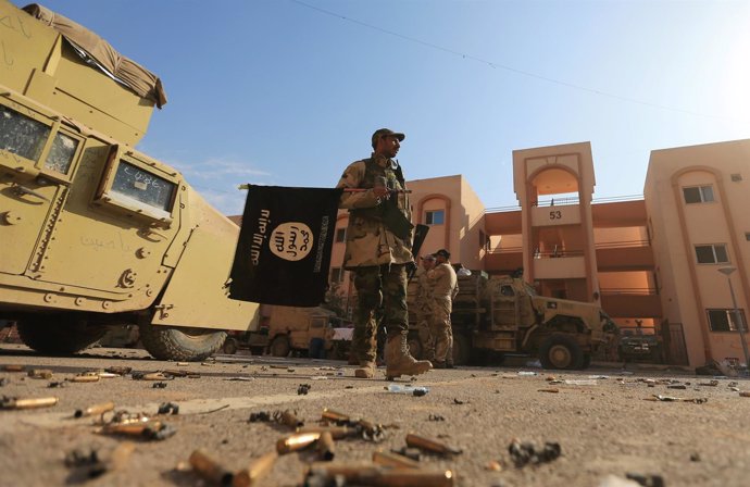 Un militar iraquí sostiene una bandera de Estado Islámico en Mosul