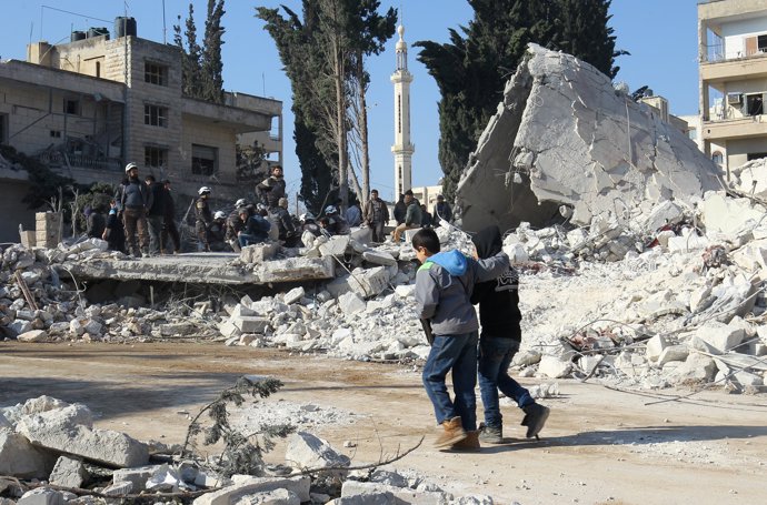 Niños caminan junto a escombros tras un bombardeo en Idlib