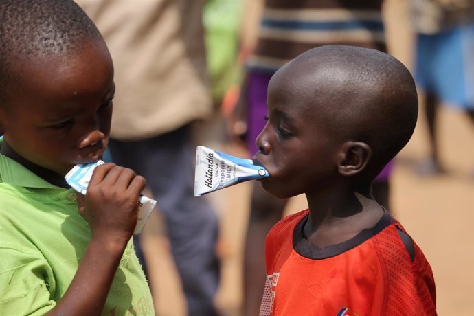 Dos niños toman leche evaporada en un campo de desplazados de Nigeria.