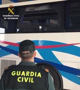 Agente de la Guardia Civil, ante un autobús escolar. 