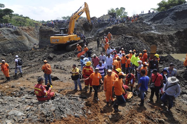 Relatives, friends and rescue workers stand at the scene where a gold mine colla