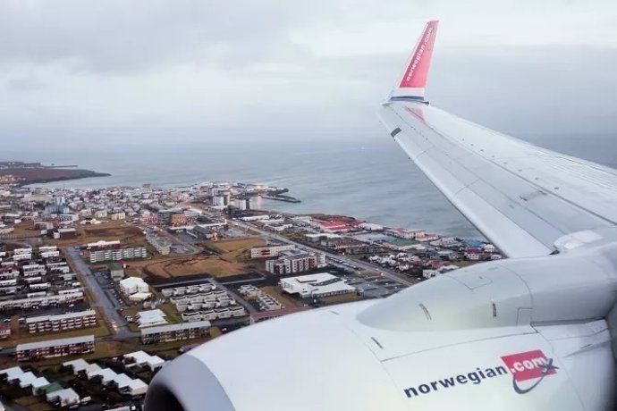 Un aparato de la compañía noruega sobrevuela una ciudad portuaria