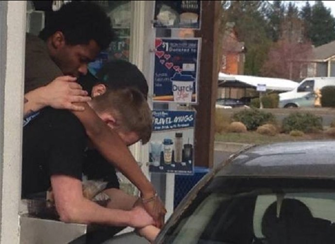 Empleados de una cadena de comida rápida rezan junto a una cliente desconsolada