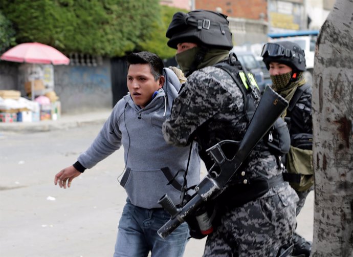 A coca grower from Yungas is arrested by riot policemen during clashes in La Paz