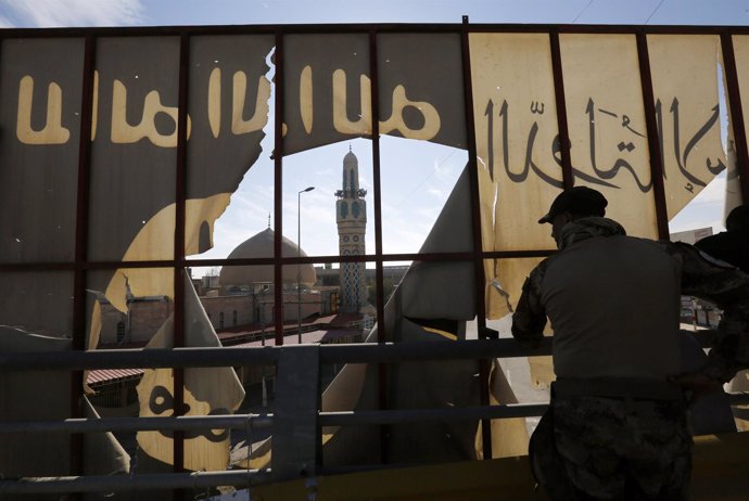 Militar iraquí junto a logo de Estado Islámico