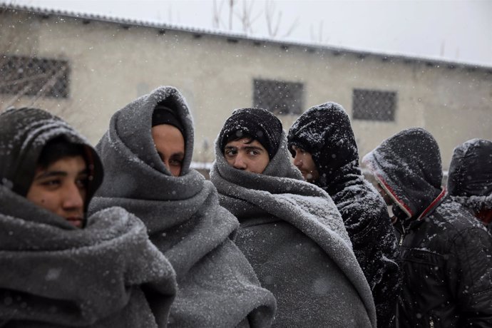 Un gupo de inmigrantes espera para comer durante una nevada en Belgrado, Serbia.