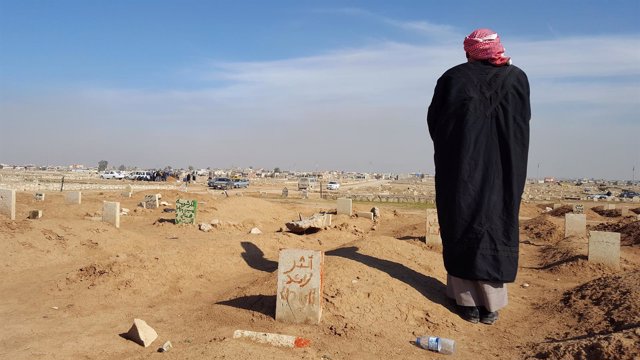 Un padre ante la tumba de su hijo en Mosul, Irak 