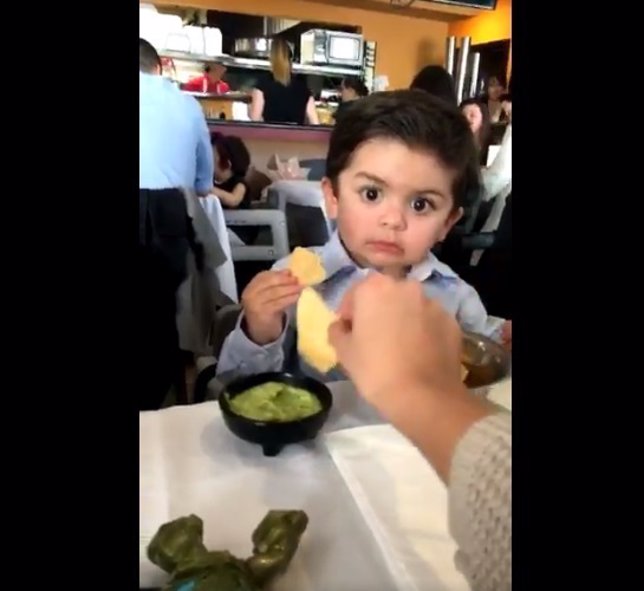 Le roba un nacho al niño y le mira con cara de incredulidad