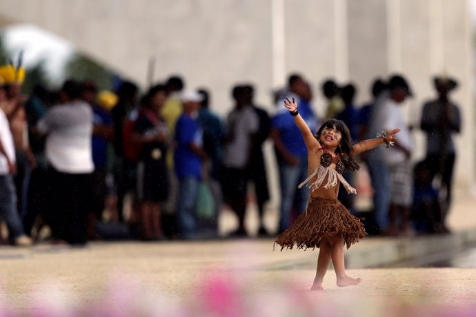 Indigenous children from the Kaingang ethnic group are seen dancing during a pro