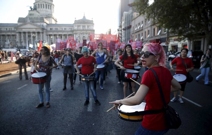 A woman beats a drum during a demonstration to mark International Women's Day an