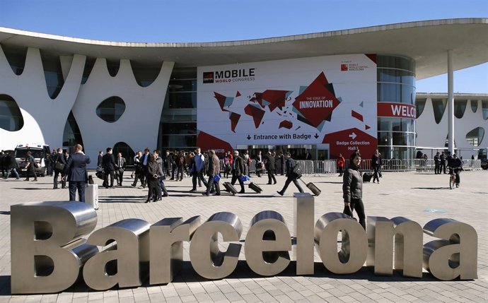 People walk next to the Mobile World Congress banner in Barcelona March 5, 2015.