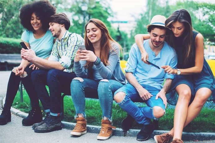 Jóvenes utilizando redes sociales en smartphones