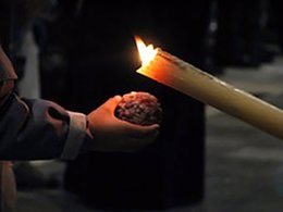 Cirio de un nazareno creando una bola de cera en Semana Santa