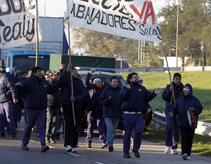 Workers shouting anti-government slogans march during a 24-hour strike across Ar