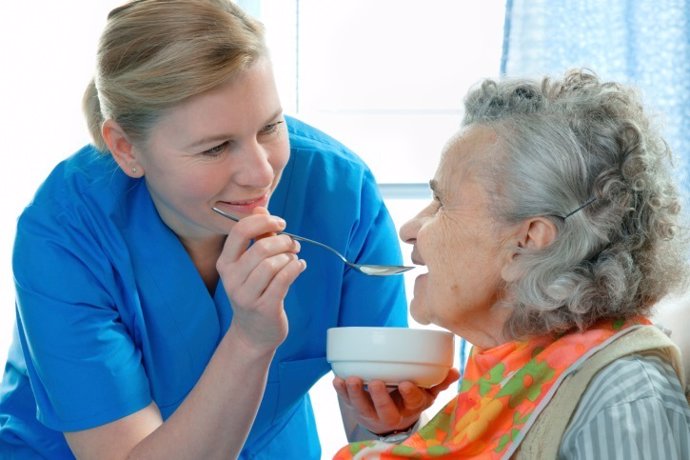 Mujer mayor con demencia o alzheimer comiendo