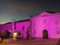 La fachada de la Asamblea de Extremadura ya luce iluminada de color morado con motivo del Día de la Mujer