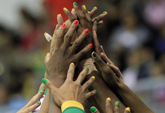 Brazil team members clasp hands before their women's preliminary round basketbal