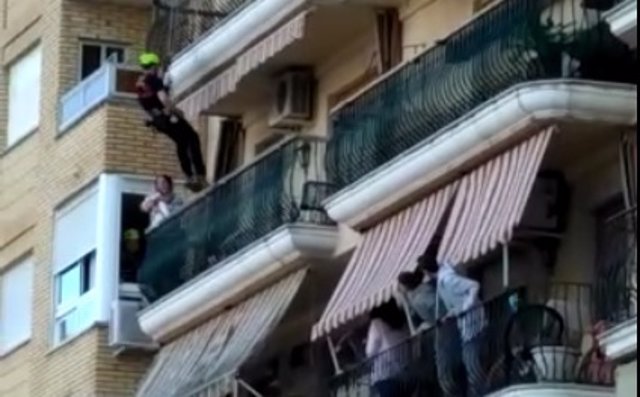 Uno de los bomberos baja hasta el balcón donde está la mujer con dos menores  