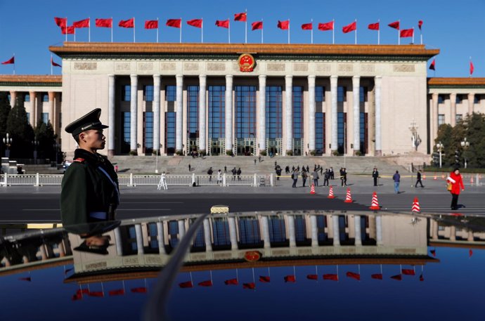 A paramilitary policeman stands guard in front of the Great Hall of the People a