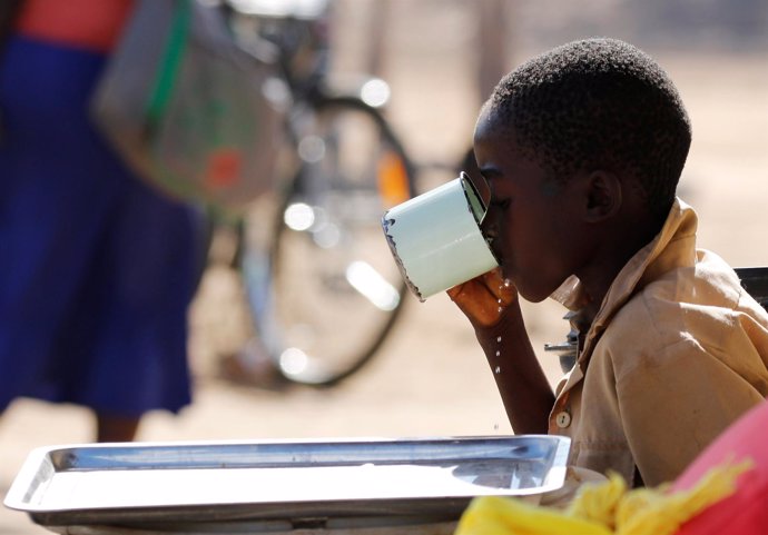 Un niño bebe agua de un vaso en Zimbabwe, 