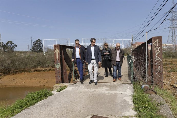 El consejero y el alcalde en el puente de hierro sobre la ría de Solía 