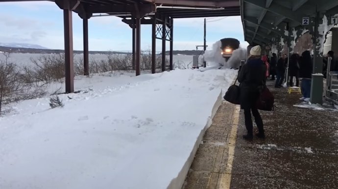 Tren americano llega a la estación salpicando enorme cantidad de nieve