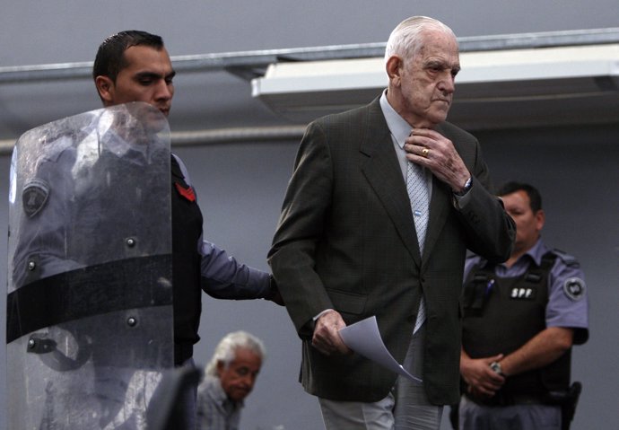 Reynaldo Bignone, a former general who ruled Argentina in 1982-1983, is escorted