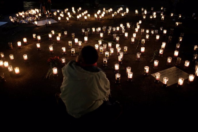 Candles are lit during a vigil for victims after a fire broke out at the Virgen 