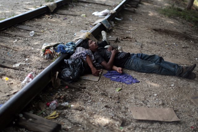 Two migrants from Guatemala sleep on the train tracks in Arriaga August 8, 2014.