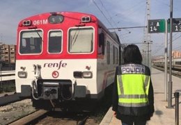 Una agente ante un tren de cercanías en la estación de Alacant Terminal