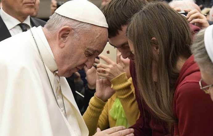 El papa resa amb dos joves en una audiència general