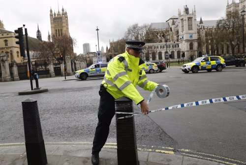 Un policía acordona la zona tras un tiroteo en frente del Parlamento Británico