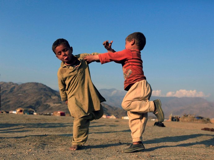 VArios niños afganos juegan en un campo de desplazados en Afganistán.