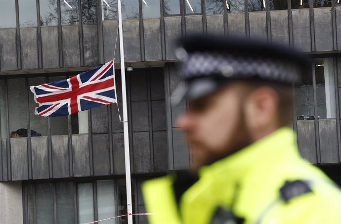 Policía con la bandera británica al fondo