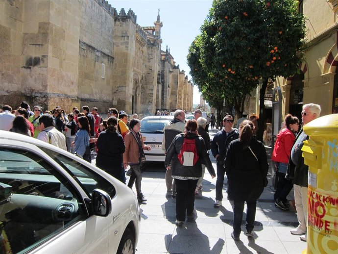 Los turistas andan entre los taxis ubicados en la acera de la calle Torrijos