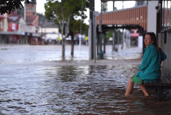 Mujer en una calle inundada en Australia por el ciclón Debbie