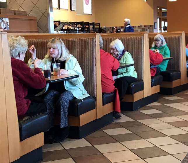 Tres parejas de señoras que visten igual en una cafetería