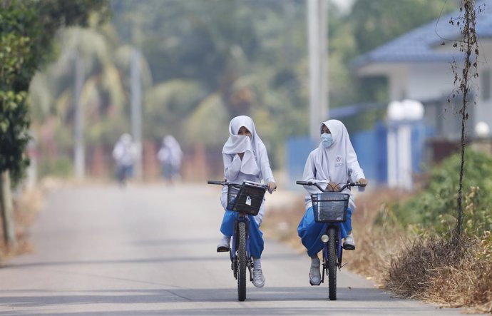 Niñas volviendo de la escuela en bicicleta