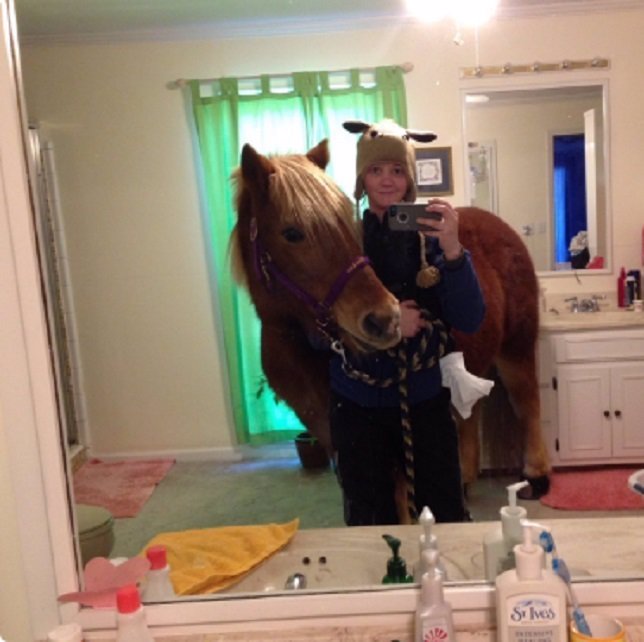 Una chica se hace un selfie en el cuarto de baño de sus padres con un caballo