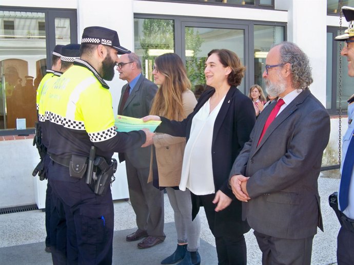 La alcaldesa de Barcelona Ada Colau entrega un diploma a un policía de barrio