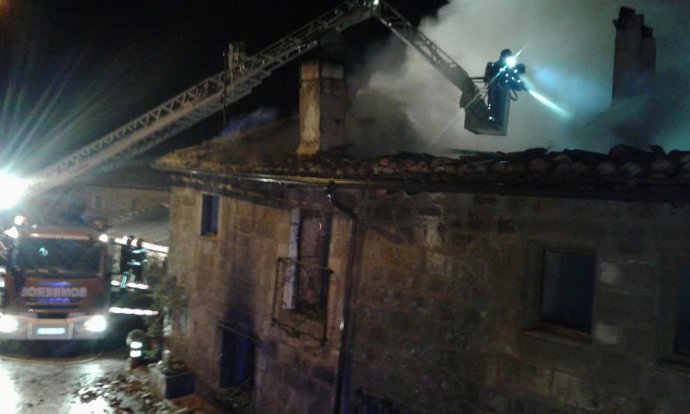 Bomberos sofocan fuego en una casa de noche. Incendio. Suceso. 