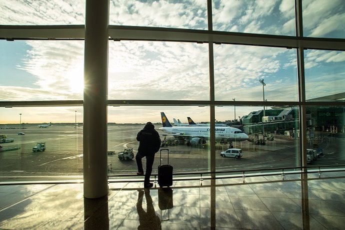 Viajero con maleta en aeropuerto