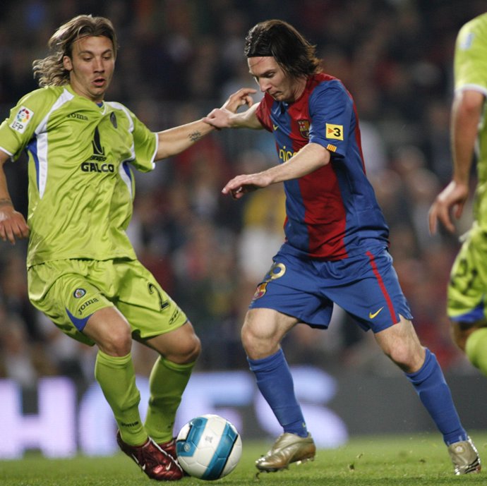 Barcelona's Leo Messi (R) fights for the ball against Getafe's Alexis Ruano Delg